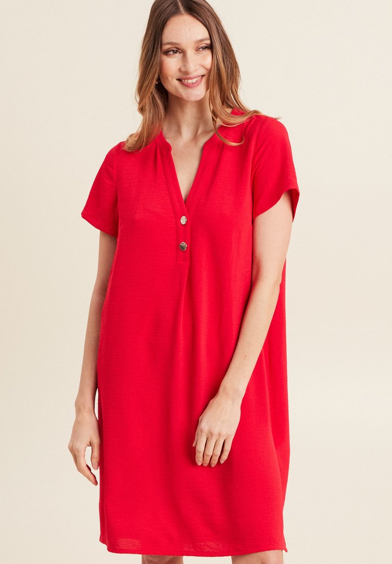 Rotes Kurzarmkleid mit V-Ausschnitt und Knopfleiste mit drei Knöpfen. Hergestellt aus leichtem Stoff, fällt locker mit einem geraden Schnitt. Keine Muster oder Akzente.