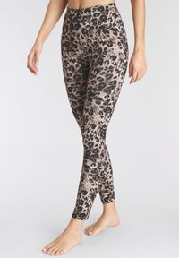 Luipaardprint legging in een mix van beige en zwart. Hooggetailleerd ontwerp met een gladde, elastische textuur. Volledige lengte met enkeldetails.