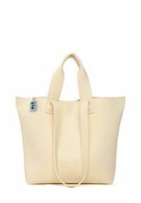 Sac fourre-tout beige en matériau synthétique texturé, avec deux poignées solides et un petit accent de label bleu. Design simple et fonctionnel.