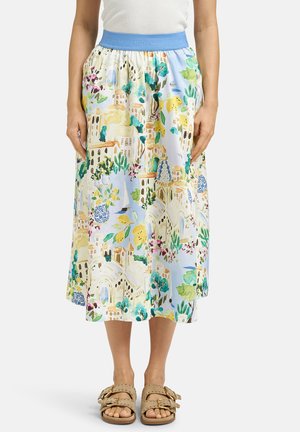 Frau trägt einen Midi-Rock mit einem blauen elastischen Bund und einem farbenfrohen Stadt- und Blumenmuster, kombiniert mit beigen Sandalen.