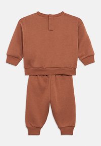 Otroški dvodelni komplet z dolgimi rokavi in hlačami z elastiko v rjavo-rjavi barvi, z rebrastimi manšetami in robom.
