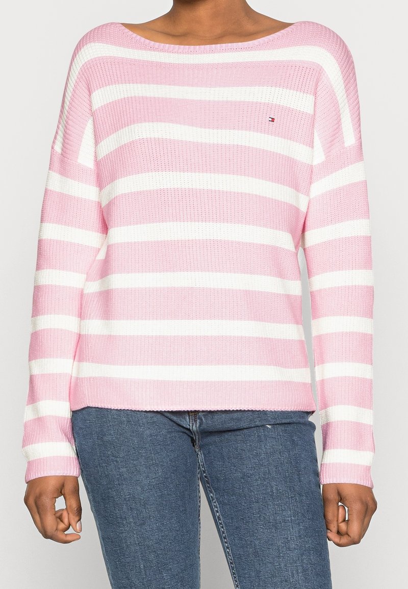 Pull-over rayé en rose clair et blanc. Il présente un large col, des manches longues et une texture côtelée. Logo sur la poitrine gauche.