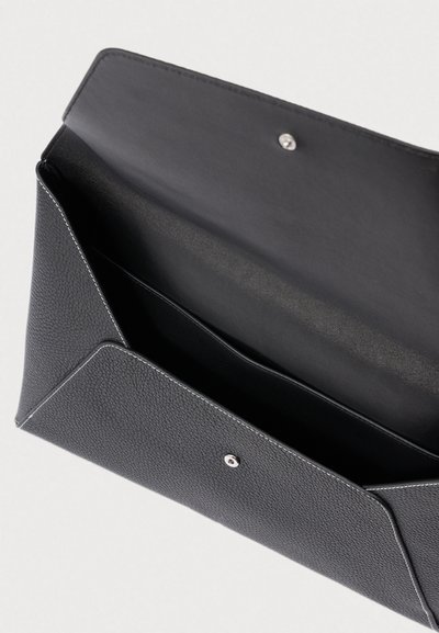 Czarna kopertówka z teksturowanej skóry z białym przeszyciem, otwieraną klapką i zapięciem na zatrzask.