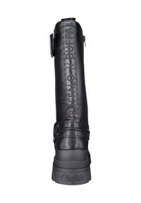 Bota de cuero negra con un diseño alto, que presenta un detalle de correa y un texto de marca prominente a lo largo del lado. Suela de goma gruesa.