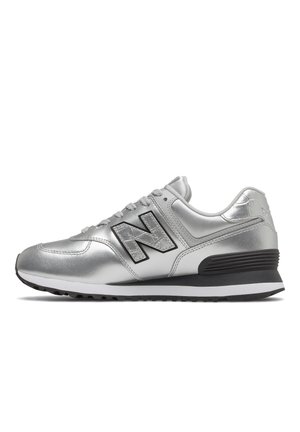 Silver metallic New Balance sneaker with black "N" logo, white midsole, black outsole, and black heel support on a white background.