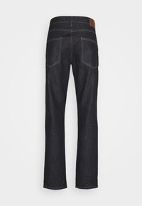 Jean en denim bleu foncé vu de dos avec deux poches et coutures blanches visibles sur un fond uni.