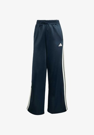 Navy sweatpants with a loose fit, made of soft fabric. Features white side stripes and an elastic waistband with a drawstring. Adidas logo present.