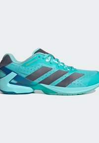 Tyrkysová sportovní obuv s vrchní částí z prodyšné síťoviny, šedými pruhy a geometrickým vzorem na podrážce. Obsahuje polstrovanou patu a zavazování na tkaničky.