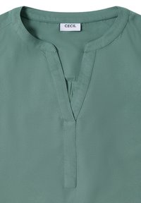 Mintgrünes Blusenshirt mit V-Ausschnitt und kurzen Ärmeln. Aus glatt verarbeitetem Stoff gefertigt, verfügt es über eine angenähte Knopfleiste und ein Etikett mit dem Markennamen "CECIL."