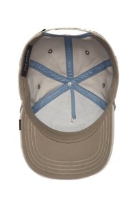 Gorra de tela beige con ala suave. Interior forrado con tela gris clara; presenta un patrón de cruces en azul y gris y una marca bordada.
