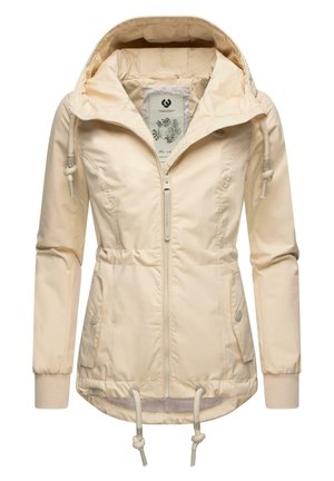 Világos bézs kabát, elöl cipzárral és kapucnival, deréknál és mandzsettáknál húzózsinórral, valamint két oldalsó zsebbel. Simább, matt felület.
