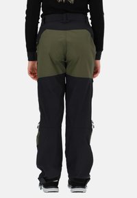 Spodnie narciarskie w kolorze czarnym i oliwkowym o trwałej teksturze, z zamykanymi na zamek kieszeniami na nogawkach, regulowanym paskiem w talii oraz szerokim krojem nogawek.