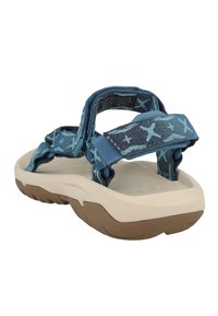 Blå og turkise mønstrede sandaler med justerbare stropper, en beige polstret såle og en teksturert underside for godt grep.