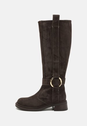 Rudų zomšinių aukštų batų iki kelių su apvaliu pirštu, cilindrine pakulne ir auksiniu metaliniu žiedo akcentu ant dirželio. Siuvinėjimo detalės palei siūles.