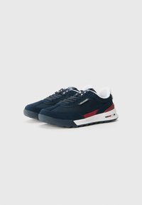 Sneakers blu navy con dettagli bianchi, striscia rossa e parte superiore in suede testurizzato e rete. Suola in gomma spessa per ammortizzazione e aderenza.