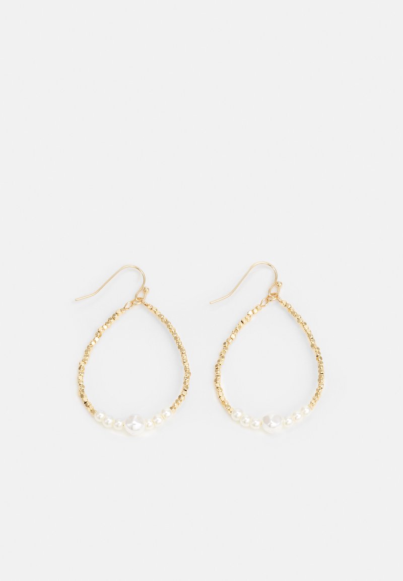 Aukso ašaros formos auskarai su tekstūruota paviršių, papuošti mažomis baltomis perlamutrinėmis kruopomis ir centrine didesne perle. Viršuje yra kabliuko uždarymas.