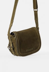 Olivenfarbene Leder-Schultertasche mit Klappenverschluss, abgerundeten Kanten, dezenten Nähten und verstellbarem Riemen. Besitzt metallene Hardware-Akzente.