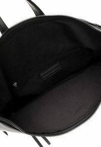 Interior de un bolso de mano de cuero negro con una textura suave, bolsillo con cremallera y forro de tela. Cuenta con una cremallera negra y una etiqueta interna.