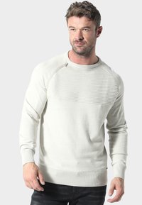 Hellgrauer Rundhalsausschnitt-Pullover mit gerippter Textur an den Schultern, flach gestricktem Körper und gerippten Bündchen. Verfügt über ein kleines metallisches Detail near dem Ausschnitt.