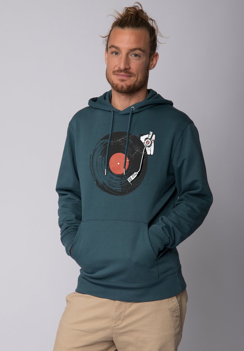 Türkisfarbener Kapuzenpullover mit einem kreisförmigen Grafikdesign eines Vinylschallplattenspielers mit rotem Zentrum und Tonarm. Mit einer Vordertasche und einer verstellbaren Kapuze.