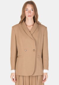 Blazer doppiopetto in tessuto beige con grandi rever, due bottoni e tasche laterali. Caratterizzato da una silhouette strutturata e maniche lunghe.