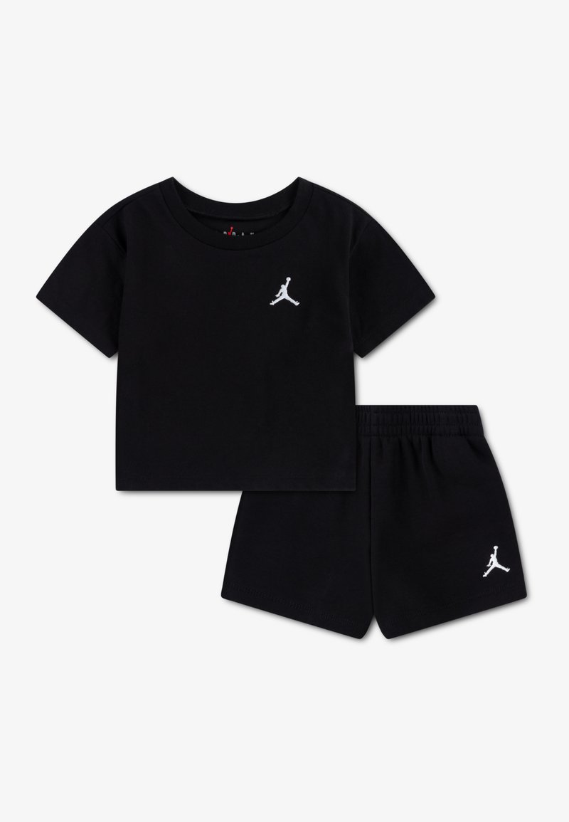 Tricou negru din bumbac cu mâneci scurte și logo Jumpman alb pe piept, asortat cu pantaloni scurți negri având un logo pe tiv.
