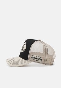 Fekete és bézs trucker sapka hálós hátsó résszel, ívelt karimával és varrás részletekkel. Az elülső és oldalsó részen logófolt található.