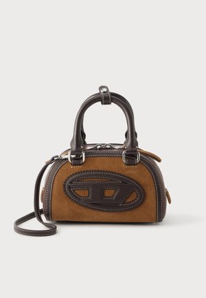 Piccola borsa marrone in camoscio e pelle marrone scuro dalla forma arrotondata, con doppi manici e tracolla removibile su sfondo bianco.