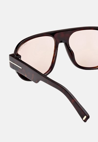 Tortoiseshell sunglasses with pink lenses, wide frames, and sleek temple arms featuring a silver accent on one side.
