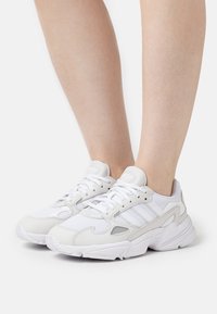Vita sneakers med en kombination av mesh och mocka-material, med en tjock sula, snörningsdesign och subtila ljusgrå detaljer.