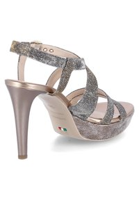 Sandale à talons hauts avec lanières métalliques argentées, plateforme taupe et un talon décoratif texturé ; sangle à cheville ajustable incluse.