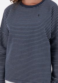 Felpa a maniche lunghe a righe navy con sottili righe bianche e scollatura rotonda. Presenta una leggera texture e un piccolo logo sul petto.