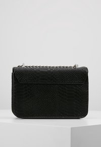 Borsa nera con motivo in pelle di serpente testurizzata, dotata di chiusura a patta e tracolla a catena argentata. Forma rettangolare con bordi lisci.