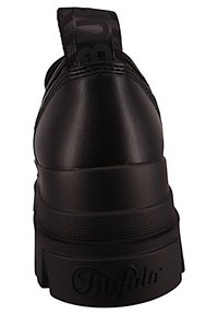 Czarne sneakersy o gładkim, matowym wykończeniu, z wyprofilowanym kołnierzem, solidną podeszwą i wytłoczonym logo na pięcie. Pasek akcentujący z tyłu.