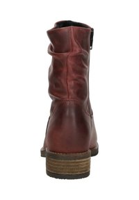 Red leather ankle boots with a slouchy design, side zipper, and a stacked wooden heel. Textured finish and rounded toe shape.