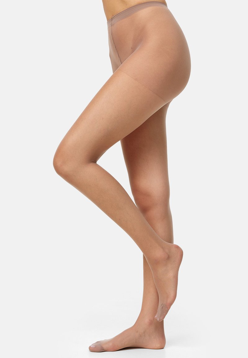 Pantys de seda en tono nude con una textura suave, que cuentan con una cinturilla alta y una opacidad uniforme. La pierna está posicionada para resaltar la silueta de la pierna.