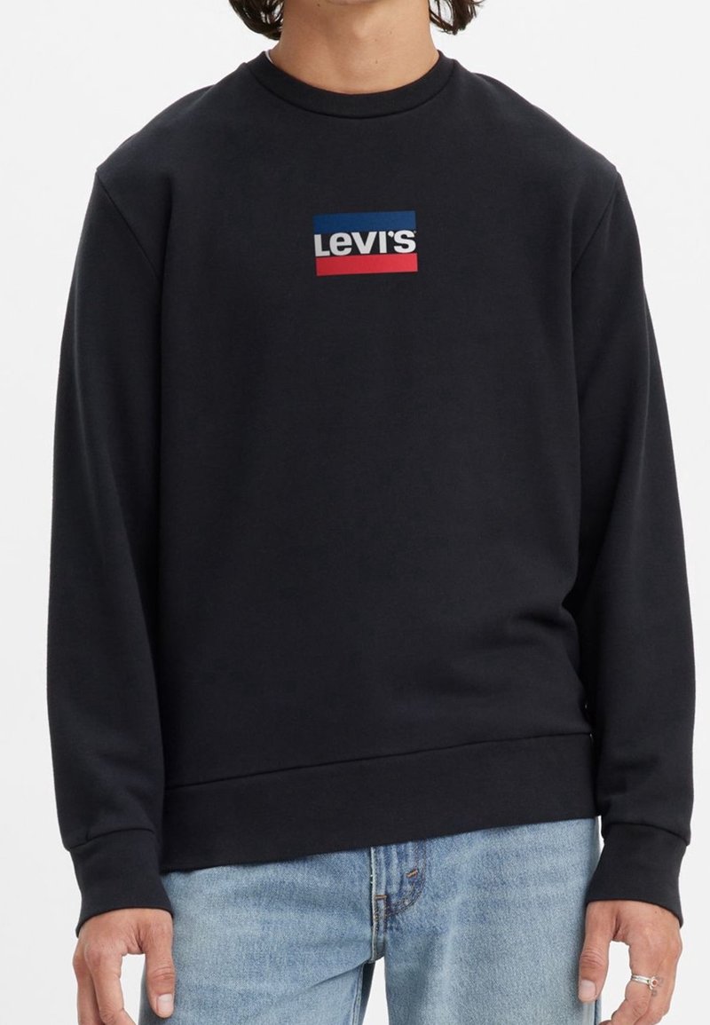 Svart sweatshirt med rund halsringning, prydd med en rektangulär Levi's-logotyp i blått, vitt och rött på framsidan. Mjuk textur och ribbade muddar.
