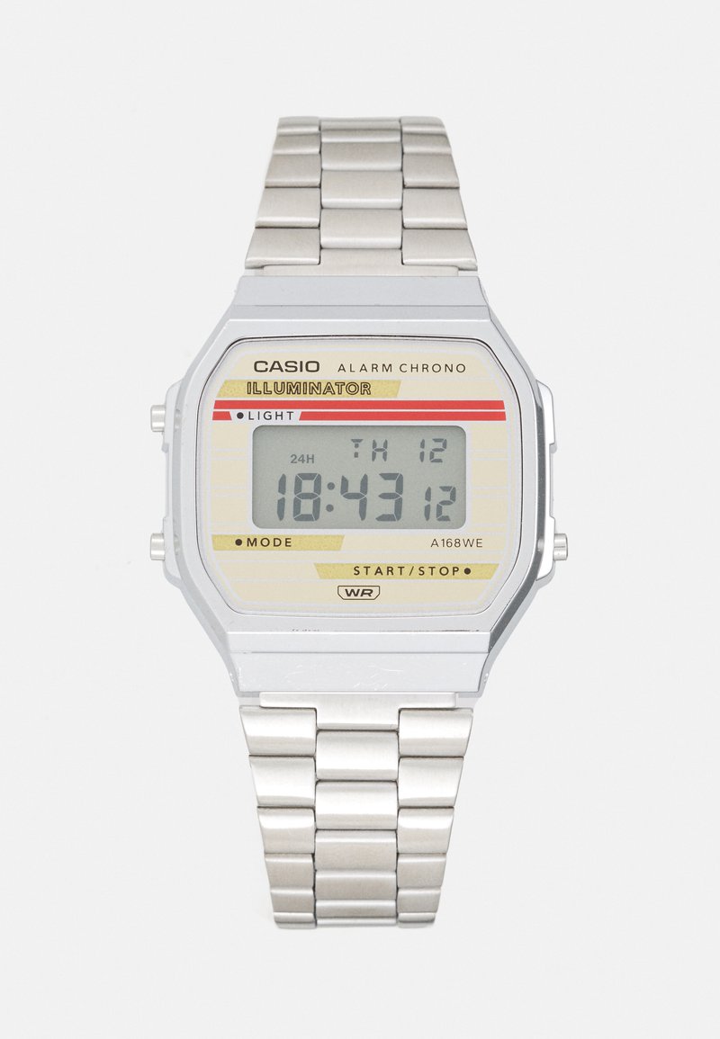 Montre numérique en acier inoxydable argenté avec un cadran rectangulaire, fond beige, accents rouges et jaunes, affichant l'heure et la date.