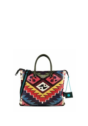 Bolsa tote con patrón tribal geométrico colorido, asas verde oscuro, correa ajustable para el hombro en negro y azul, y un pequeño bolso adjunto.