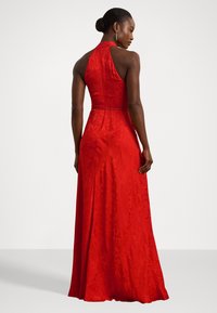 Rochie roșie din satin cu gât halter, cu corset adaptat, fustă fluidă, model floral texturat și talie accentuată de un brâu subțire.
