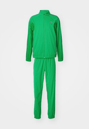 Chándal verde fabricado en tela ligera; presenta una chaqueta con cremallera y pantalones con cintura elástica, puños de canalé y detalle de logo.