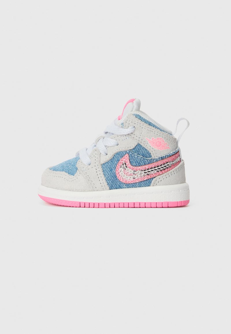 Nike babysneakers med en kombinasjon av lys grå semsket skinn og blå denim, med rosa aksenter og en paljettlogo på siden.