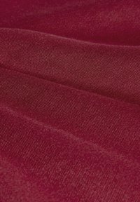 Tela burdeos con una superficie suave y texturizada, que presenta un patrón tejido de manera ajustada y un brillo sutil, cayendo en suaves pliegues.