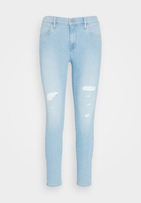 Pantalones vaqueros ajustados en azul claro hechos de mezclilla, con detalles desgastados en los muslos, que cuentan con un diseño clásico de cinco bolsillos y cierre de cremallera.