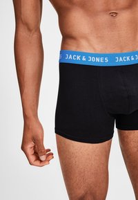 Schwarze Boxerbriefs mit einem blauen Bund, auf dem "JACK & JONES" steht. Aus weichem Stoff mit einer bequemen Passform, die ein klassisches Design präsentiert.