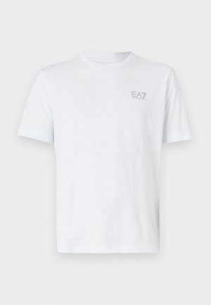 Vit bomull t-shirt med rund hals, kort ärm och en liten grå EA7-logotyp på övre vänstra sidan. Slät textur, klassisk passform.