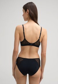 Zwart lingerieset met een kant bodice met een bloemenpatroon, verstelbare banden en een bijpassende high-waisted onderkant met mesh accenten.
