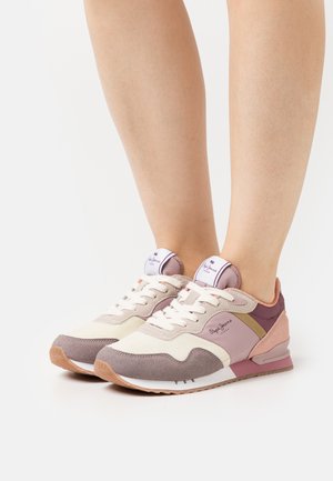Zapatillas ligeras en crema, rosa claro y gris. Presentan un tejido texturizado, un collar acolchado y una suela de goma con un patrón de tracción.