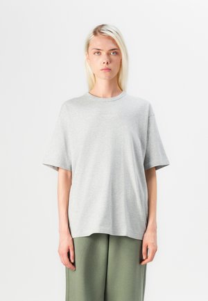 Šedé bavlněné tričko s uvolněným střihem, kulatým výstřihem, krátkými rukávy a malým logem na hrudi. Jednoduchý design.