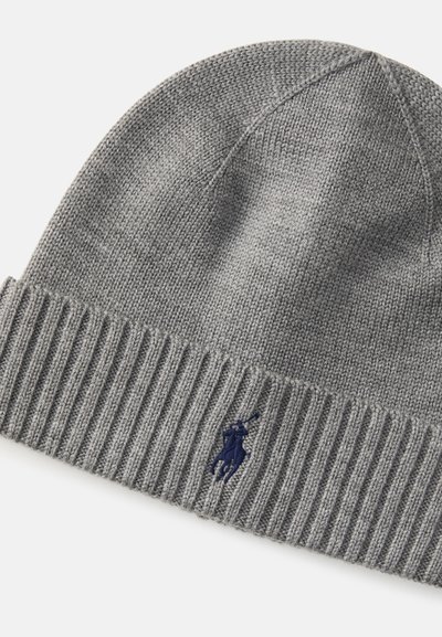 Gorro de malha cinza com punho canelado e um pequeno logotipo azul marinho. A textura parece suave e elástica, adequada para o clima frio.